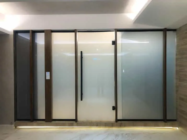 Wide frosted glass panels with dark frames in a lit interior