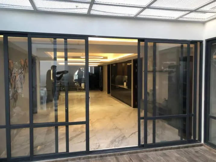 Black-framed sliding glass doors connecting a tiled room to another space