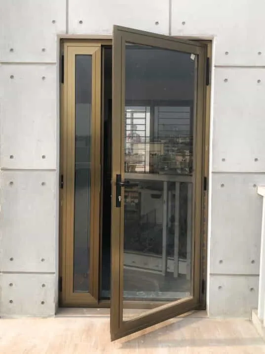 Dark-framed glass door standing open in an unfinished wall
