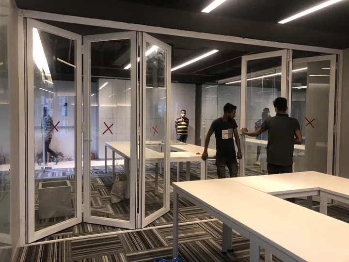 White-framed folding glass panels beside an interior counter