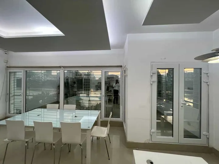 Dining area enclosed by white-framed glazed openings