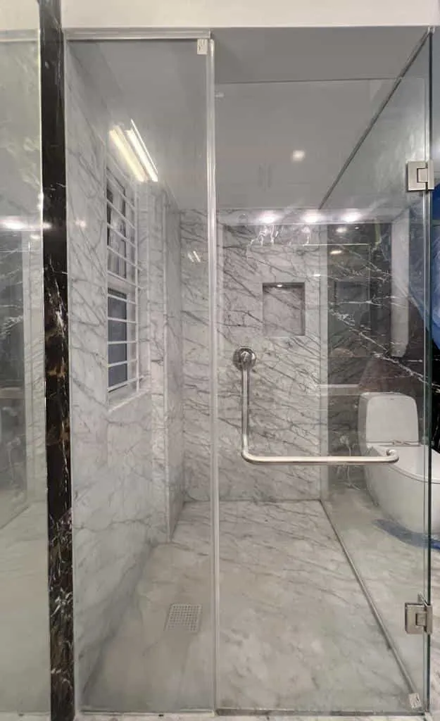 Glass shower enclosure and tiled bathroom interior