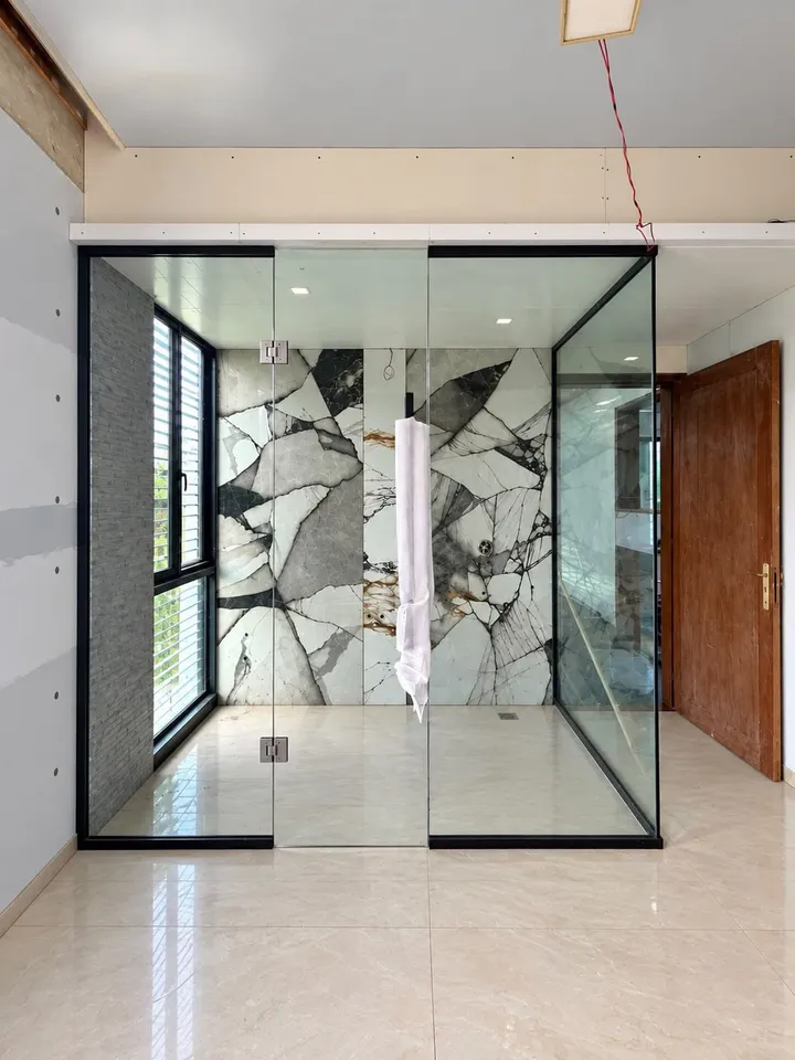 Black-framed clear glass enclosure inside a bright tiled room