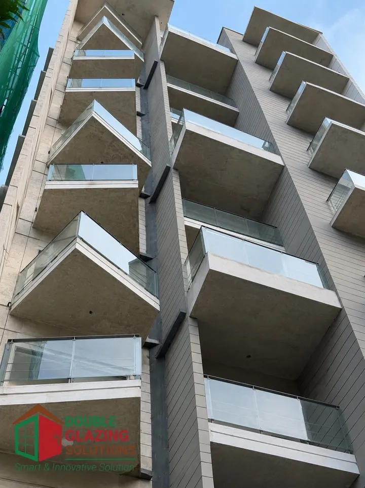 Upward view of a building with projecting balconies and pale cladding