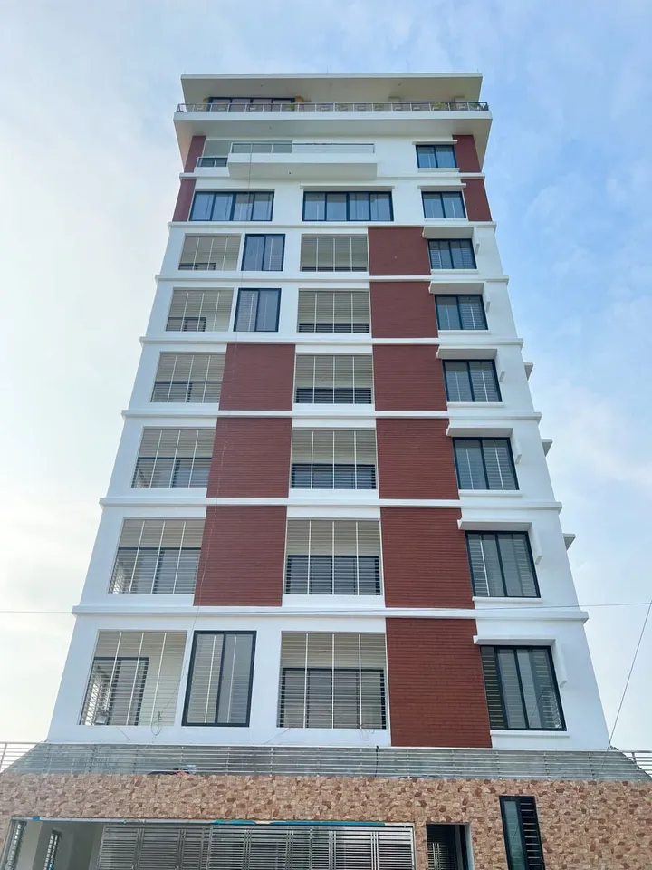 Tall building with red vertical façade panels and repeated glazing