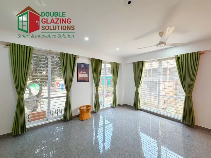 Bright room with windows on adjacent walls and green curtains