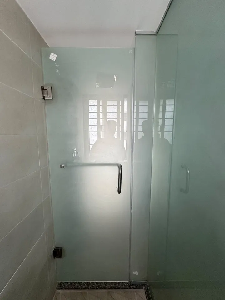 Glass shower enclosure against pale bathroom tiles