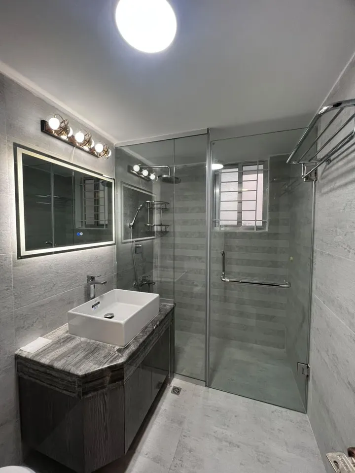 Tiled bathroom with a glass shower screen beside a basin