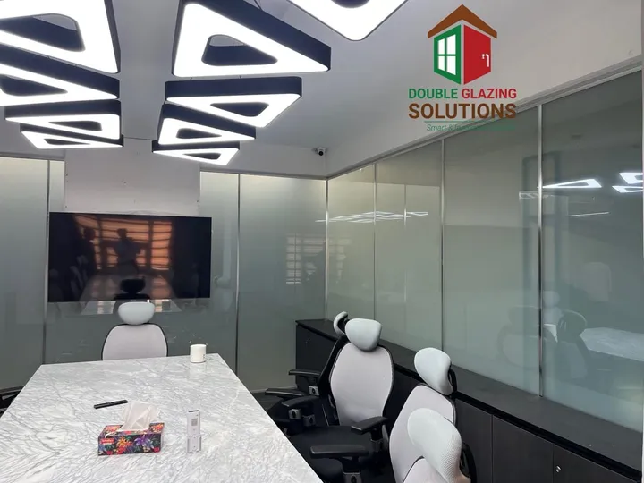 Glass partitions surrounding a furnished meeting room