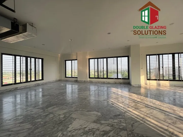 Unfurnished room with large windows casting warm light across the floor