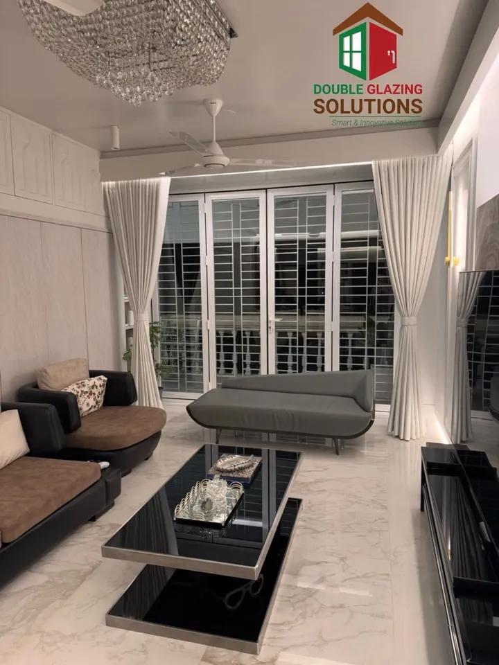 Living area with white curtains and dark-framed windows