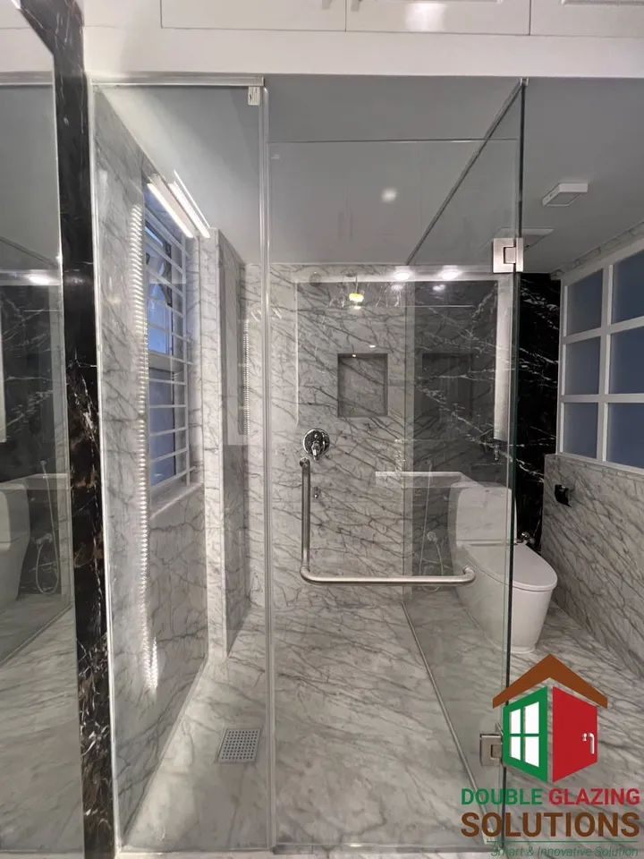 Tiled bathroom with a transparent glass shower enclosure