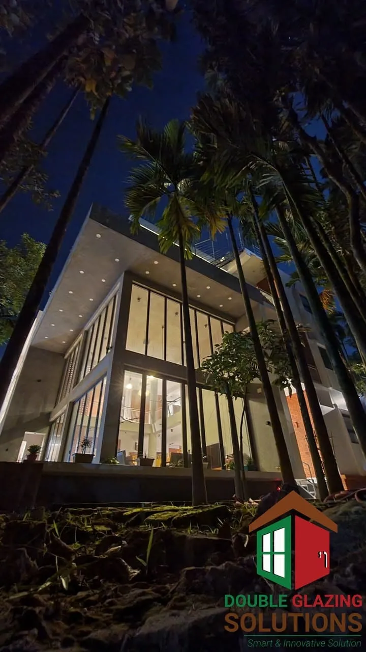 Illuminated glazed exterior at night among palm trees