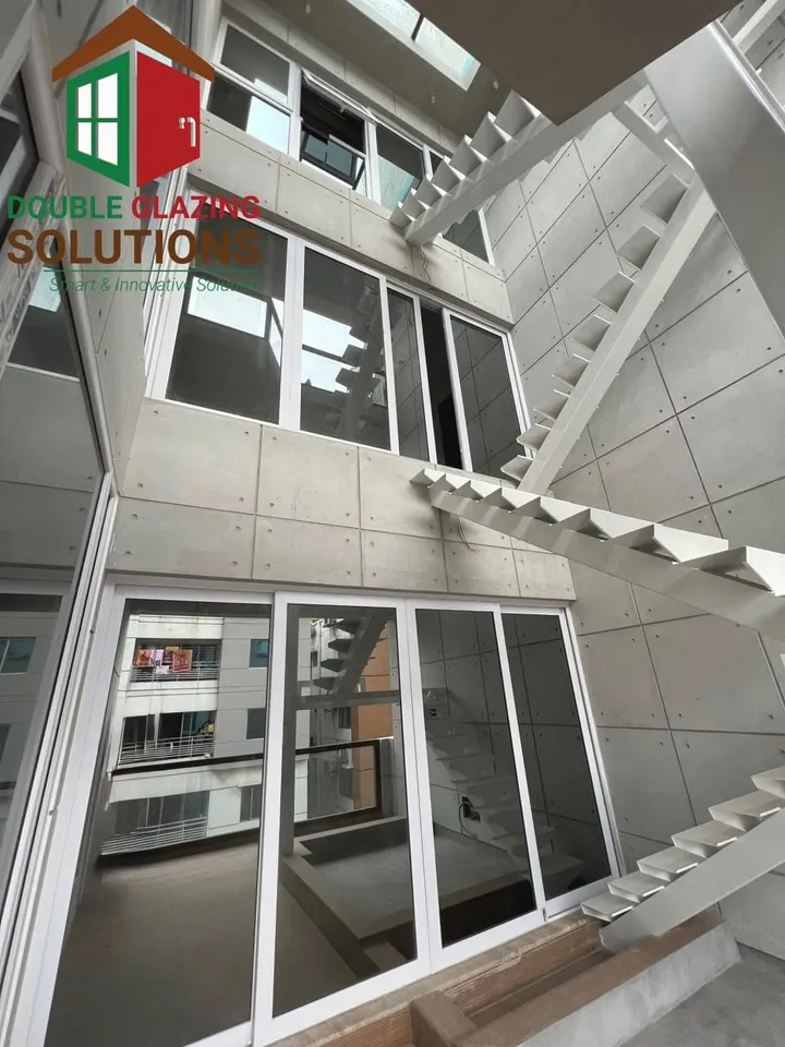 Upward view of white-framed windows around an internal courtyard