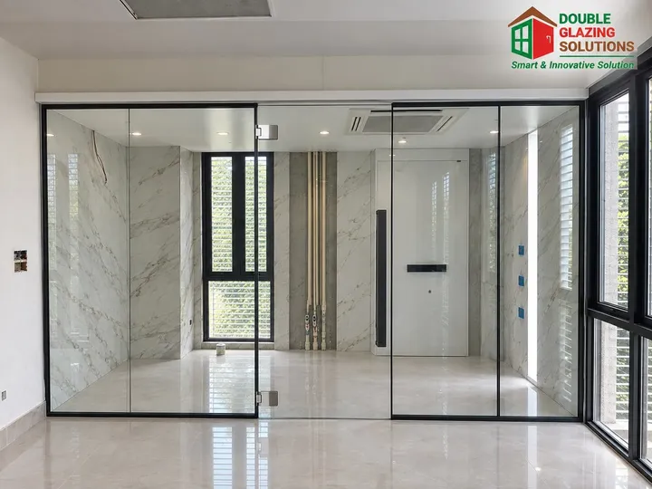 Black-framed glass enclosure in a pale tiled interior