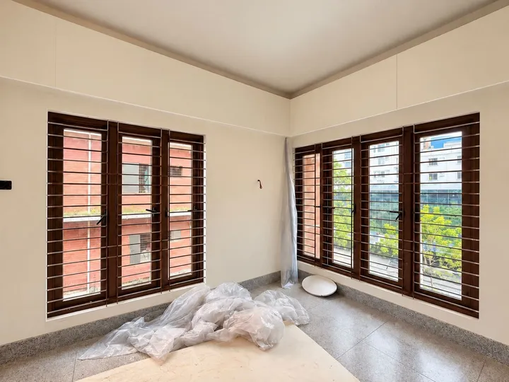 Room under construction with brown-framed windows on two walls
